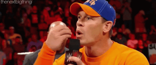 Man In Orange Shirt Blue Hat On Mic GIF