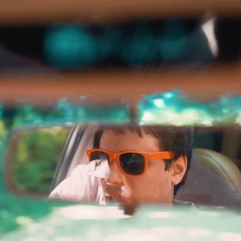 Man in Orange Sunglasses Looking Out Car Window