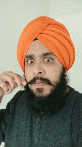 Man In Orange Turban And Black Shirt Holding Mustache GIF