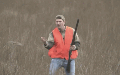 Man in Orange Vest Holding Gun