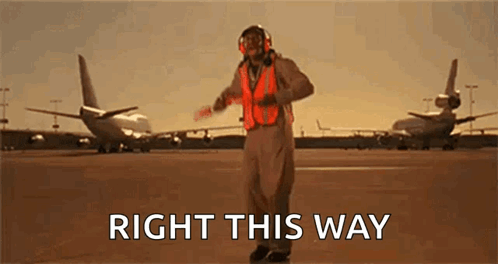 Man in Orange Vest on Runway Says Right This Way