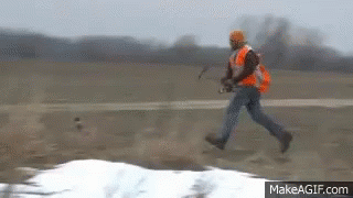 Man in Orange Vest Running in Field