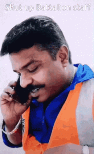 Man in Orange Vest Talking on Phone