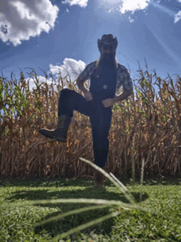 Man in Overalls and Cowboy Hat in Cornfield