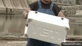 Man in Overalls Carrying White Cooler