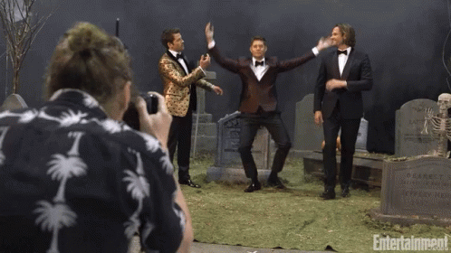 Man in Palm Tree Shirt Photographs Three Tuxedo Men at Cemetery