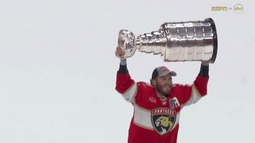 Man in Panthers Jersey Holding Trophy