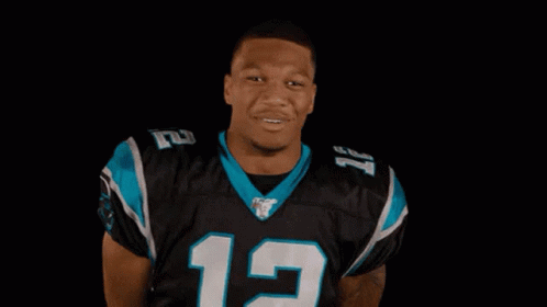 Man in Panthers Jersey Smiling and Clapping