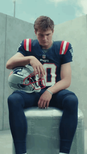 Man in Patriots Jersey With Helmet on Lap