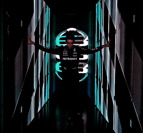 Man in Petronas Shirt in Dark Hallway