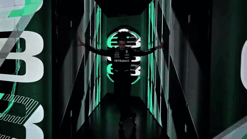 Man in Petronas Shirt Standing in Dark Tunnel