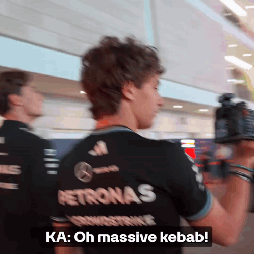Man in Petronas Shirt Talking to Someone