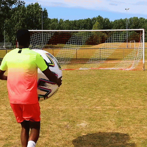 Man In Pink And Yellow Holding Soccer Ball GIF
