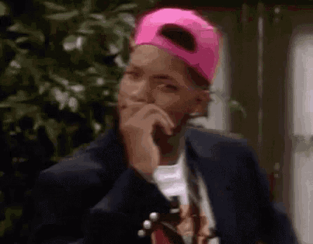 Man in Pink Baseball Cap and Suit Covering Mouth