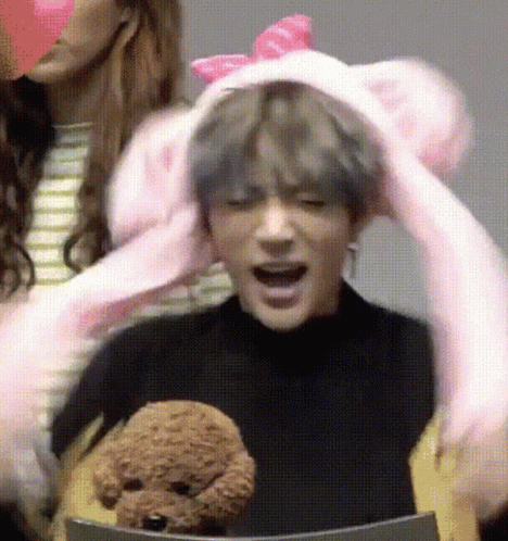 Man in Pink Bunny Hat Holding Stuffed Animal