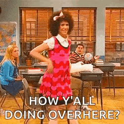 Man in Pink Dress Dancing in Classroom While Woman Sits at Desk