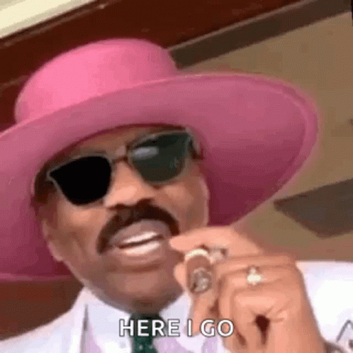Man in Pink Hat and Sunglasses Holding Cigar