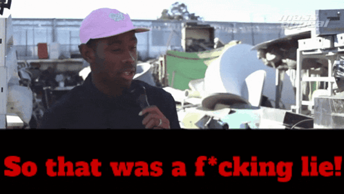 Man in Pink Hat Talking Into Microphone Saying So That Was a F*cking Lie