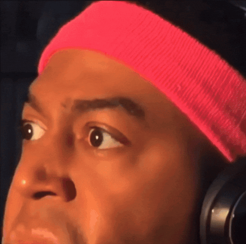 Man in Pink Headband and Headphones Looks Surprised