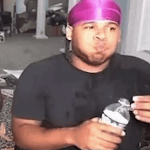 Man in Pink Headband Holding Water Making Funny Face