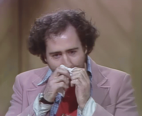 Man in Pink Jacket and Red Tie Holding Paper in Mouth