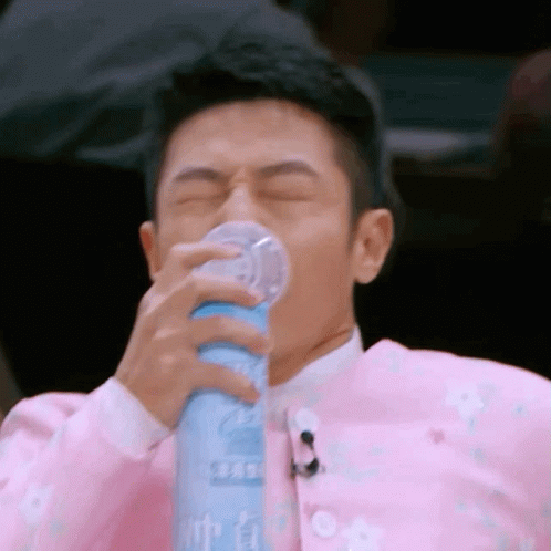Man In Pink Jacket Drinking From Bottle GIF