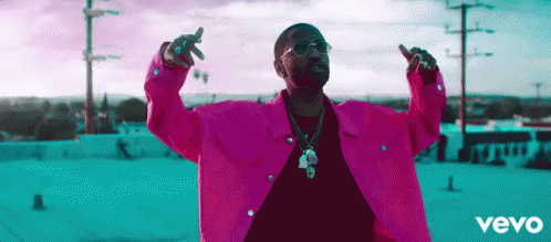 Man in Pink Jacket with Arms Outstretched on Roof