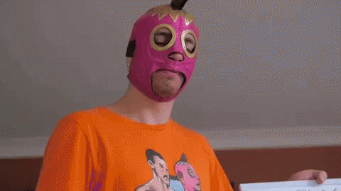 Man in Pink Mask and Orange Shirt Holding Paper