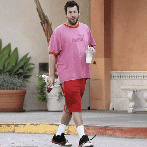 Man in Pink Puma Shirt and Red Shorts Walking