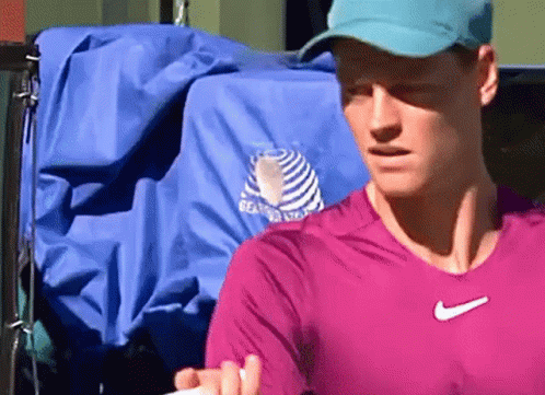 Man In Pink Shirt And Blue Hat Holding Tennis Racket GIF