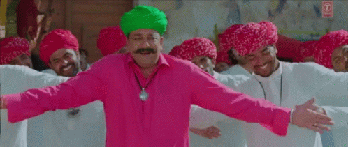 Man In Pink Shirt And Green Turban Dancing With Turbaned Men GIF