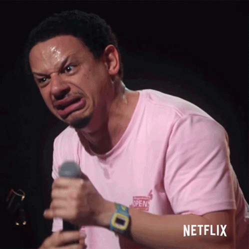 Man In Pink Shirt Holding Microphone With Netflix Logo GIF
