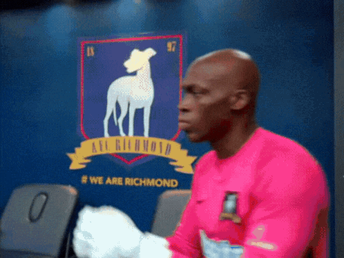 Man In Pink Shirt In Front Of Richmond Wall GIF