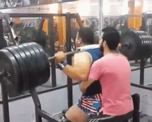 Man In Pink Shirt Lifting Barbell With Onlooker GIF