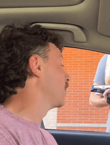 Man in Pink Shirt Sitting in Car