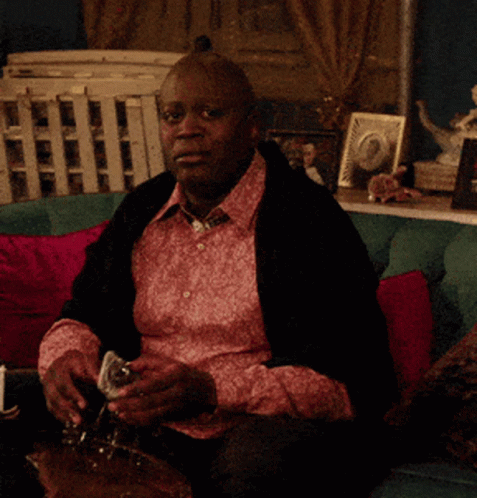 Man In Pink Shirt Smoking On Couch GIF