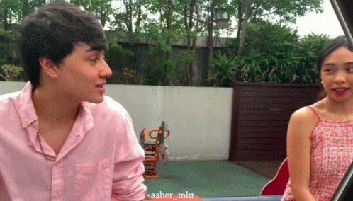 Man In Pink Shirt Talking To Woman In Red GIF