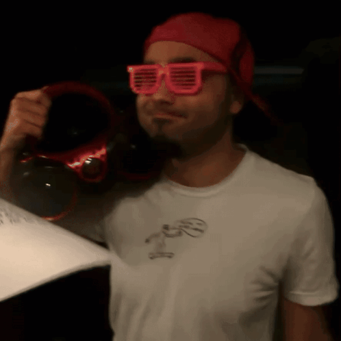 Man in Pink Sunglasses and Red Hat Holding Headphones