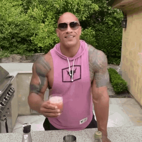 Man in Pink Tank Top Holding Drink