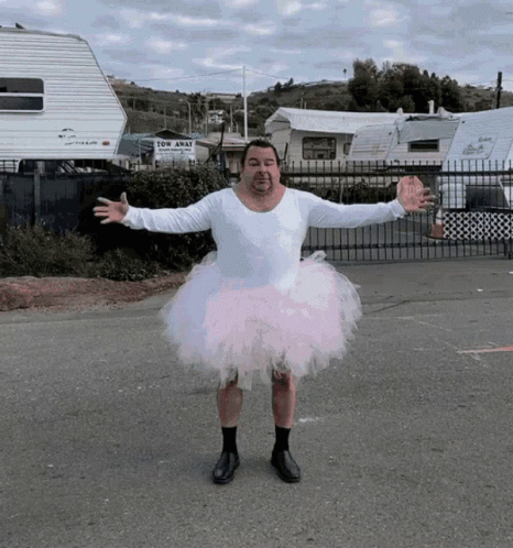 Man in Pink Tutu in Front of Tow Away Trailer