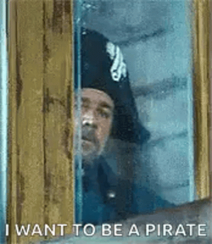 Man in Pirate Hat Looking Out Window