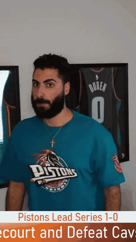 Man in Pistons T-Shirt in Front of Framed Jersey