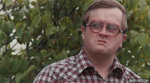 Man in Plaid Shirt and Glasses by Bush
