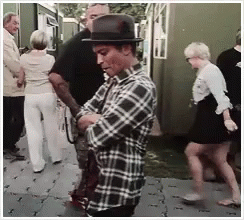 Man In Plaid Shirt And Hat On Sidewalk GIF