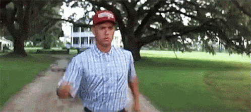 Man in Plaid Shirt and Red Hat Running