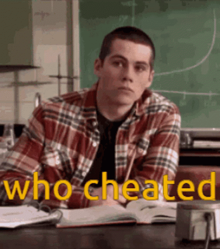Man in Plaid Shirt at Desk With Chalkboard Saying Who Cheated