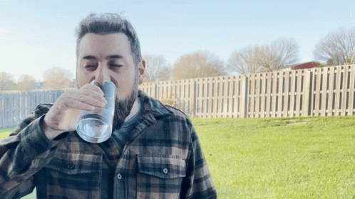 Man in Plaid Shirt Drinking from Glass
