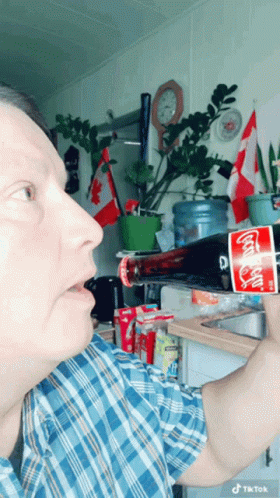 Man in Plaid Shirt Drinks Coca Cola