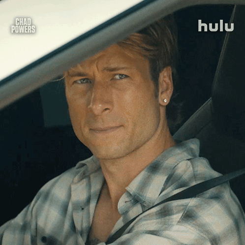 Man in Plaid Shirt Driving Car With Hulu Logo