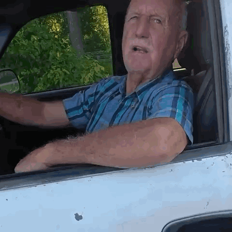 Man in Plaid Shirt Driving White Truck
